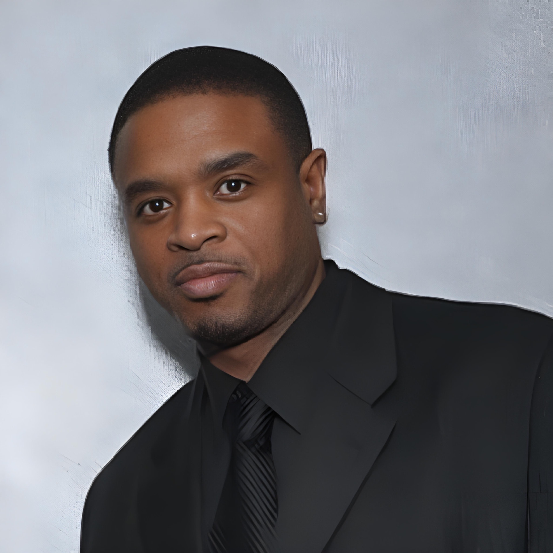 Eddie F studio headshot in a black suit